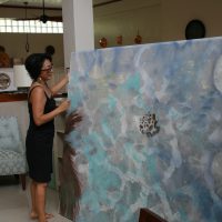 Artist Noe Tanigawa prepares to install her painting at the residence of U.S. Ambassador to Palau.