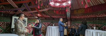 At a reception at the residence of U.S. Ambassador David Rosenblum in Astana, American artist Ángel Rafael Vázquez-Concepción talks with assembled guests including Kazakh artist and activist Karipbek Kuyukov.