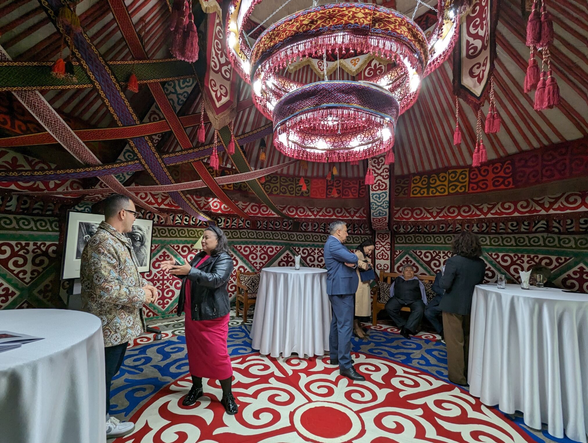 At a reception at the residence of U.S. Ambassador David Rosenblum in Astana, American artist Ángel Rafael Vázquez-Concepción talks with assembled guests including Kazakh artist and activist Karipbek Kuyukov.